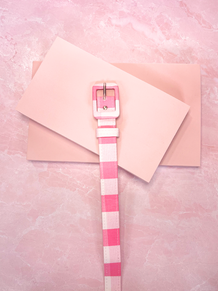 Add a touch of playful vintage charm with this 1" pink and white gingham sateen belt, perfect for defining your waist with a classic, feminine flair. A sweet accessory to pair with your favorite vintage-inspired dress.