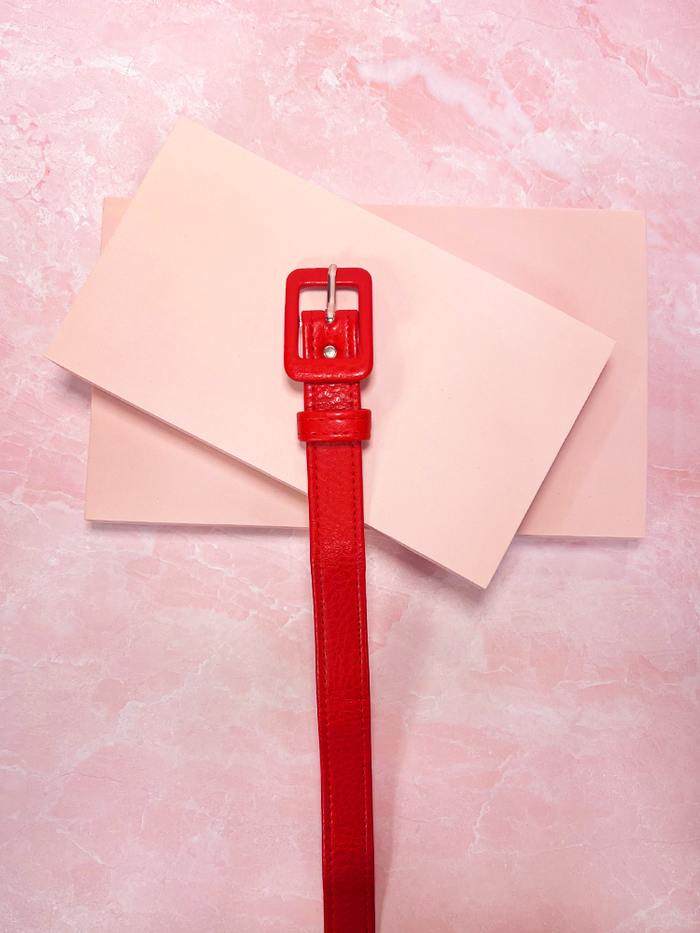 Add a bold, retro touch to your outfit with this red leather belt, perfect for cinching your waist and creating a classic, vintage-inspired silhouette.