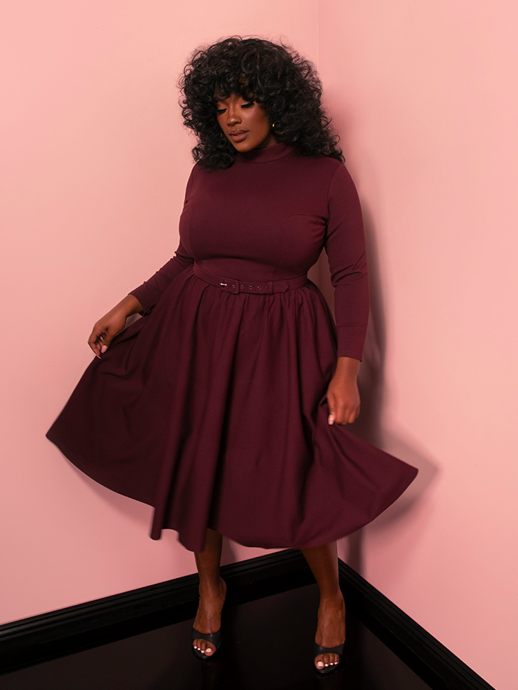 The Bad Girl Swing Dress in merlot blends sultry sophistication with a vintage flair, featuring a flattering fit-and-flare silhouette that channels timeless elegance.