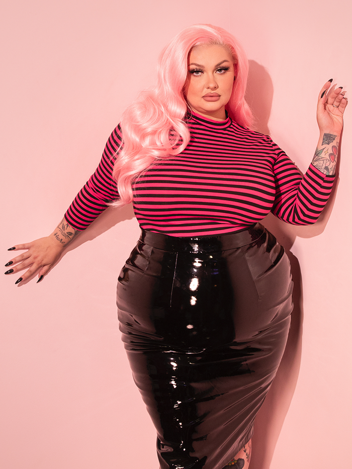 The Bad Girl 3/4 Sleeve Top in Pink and Black Stripes offers a retro-inspired look with bold stripes and a fitted silhouette, perfect for adding vintage edge to your style.