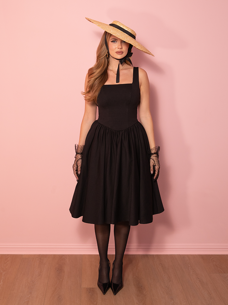 Step into retro sophistication, with this black swing dress that embodies the refined glamour of the 1950s while offering modern comfort and style.
