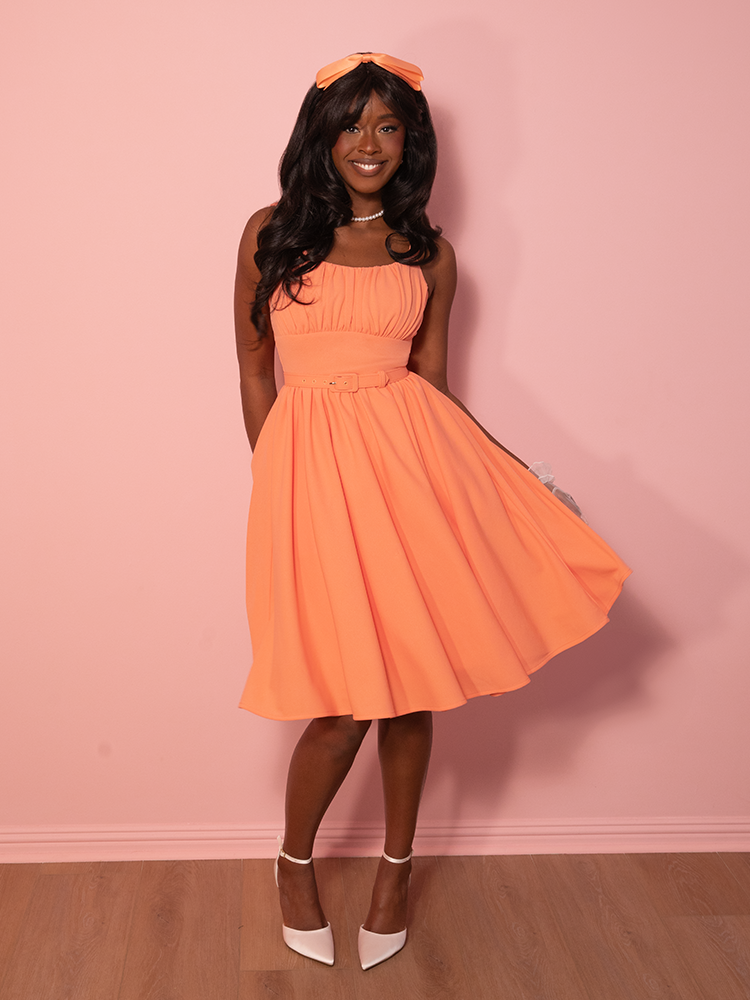 Step into retro elegance, with this creamsicle-hued dress that captures the essence of 1950s fashion while offering modern comfort and style.
