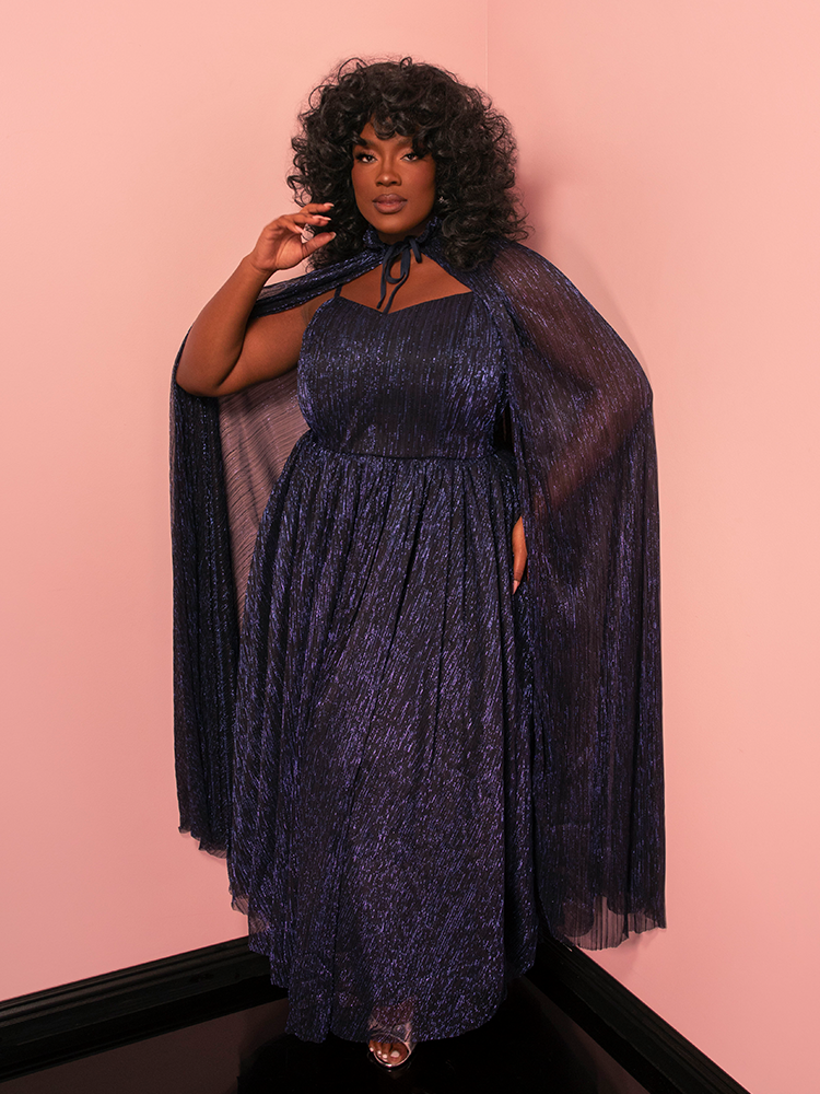 This midnight blue Jareth gown with a matching cape captures classic Hollywood's ethereal charm.