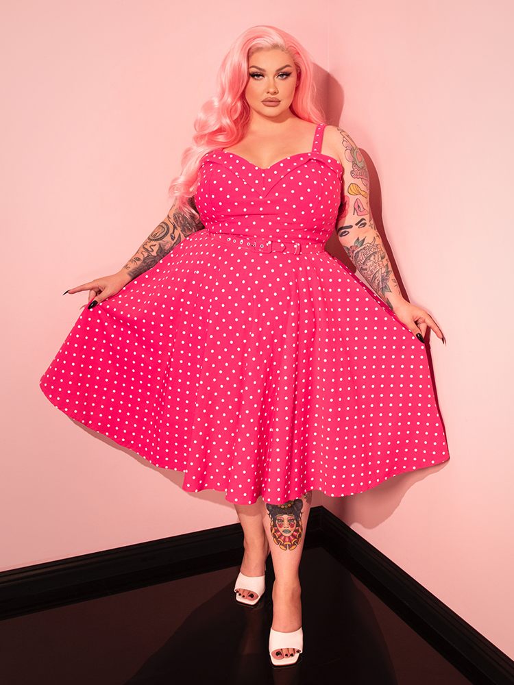 Bring a touch of retro flair to your wardrobe with the Maneater Pink Polka Dot Swing Dress, designed to flatter with its timeless swing style.