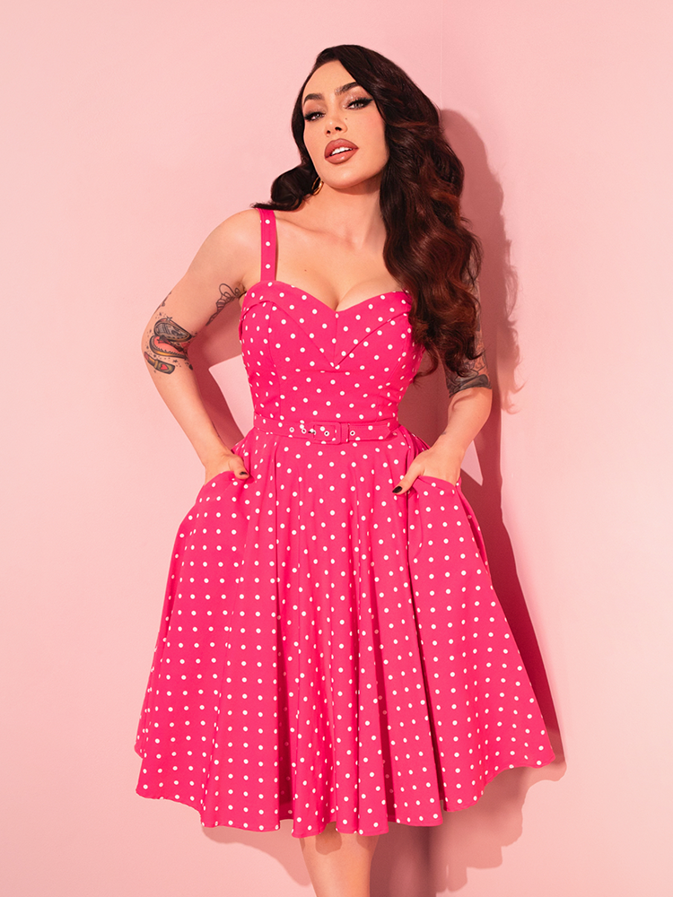 Turn heads with the Maneater Pink Polka Dot Swing Dress, a retro-style dress that embodies the spirit of the '50s with its bold print and feminine cut.