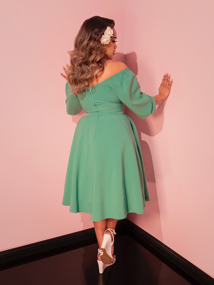 Add a retro flair to your travel wardrobe with this moss green vacation dress, designed for timeless elegance.