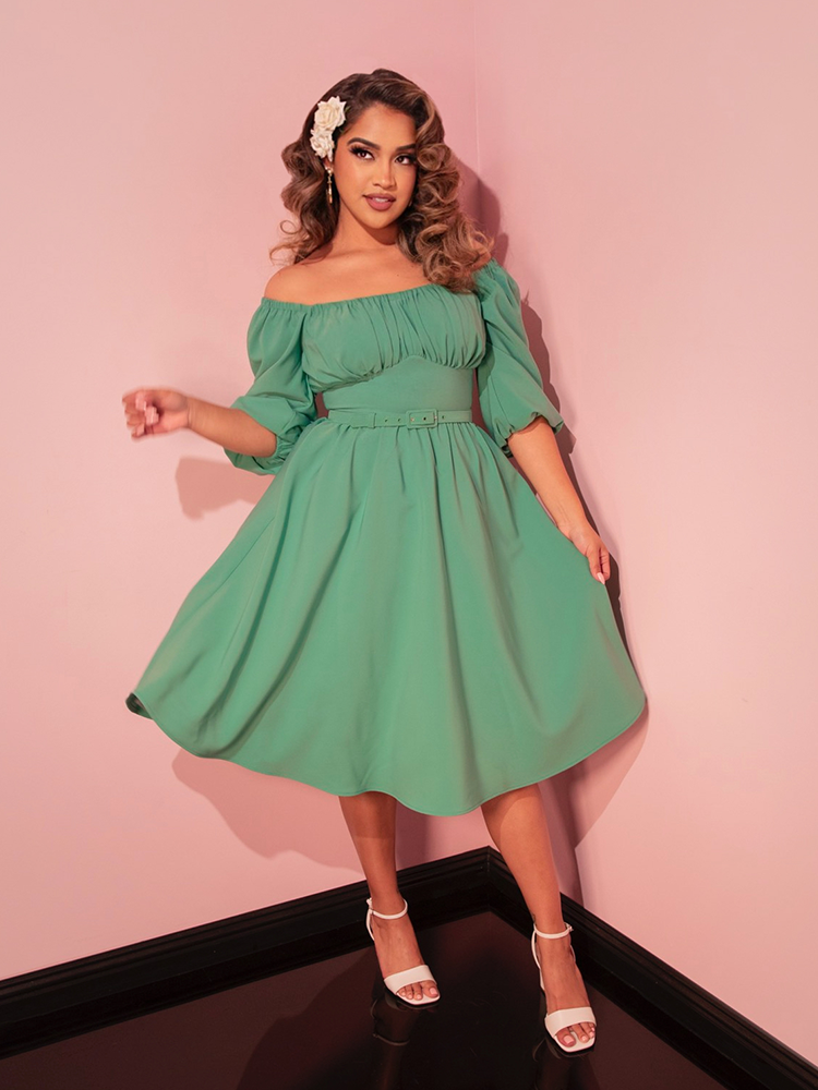 Capture vintage vibes with this moss green vacation dress, ideal for creating a timeless and sophisticated vacation ensemble.