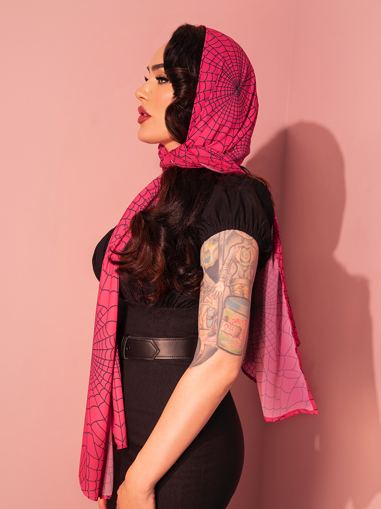 This 1950s-inspired chiffon scarf in hot pink spider web print brings a vibrant splash of color and retro flair to any outfit. Ideal for adding a touch of vintage style with a quirky, modern twist.