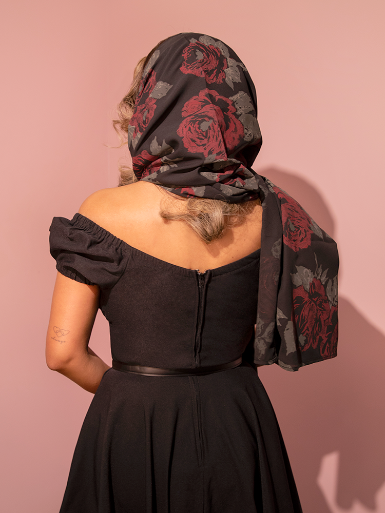 Elevate your wardrobe with this retro-inspired chiffon scarf in black rose print, offering a delicate blend of vintage charm and modern flair.