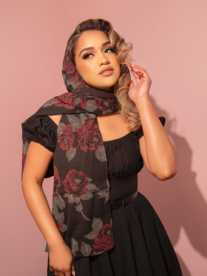 Embrace timeless elegance with this 1950s-inspired chiffon scarf in black rose print, adding a touch of vintage sophistication to any outfit.