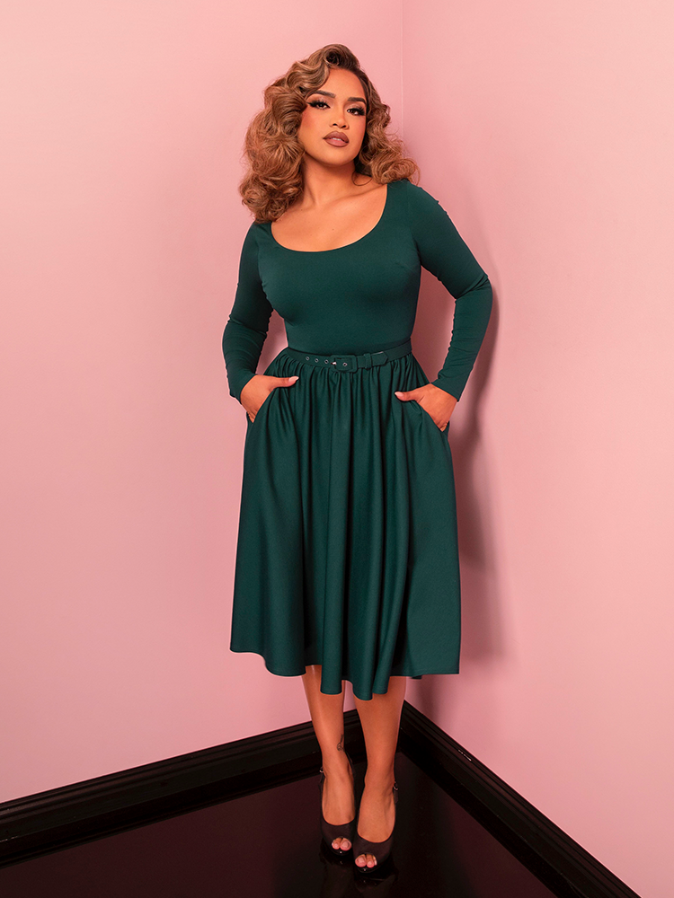 The Troublemaker Swing Dress in spruce green is a classic Hollywood-inspired design that combines elegance and comfort. Its flattering fit-and-flare silhouette makes it perfect for any special occasion.