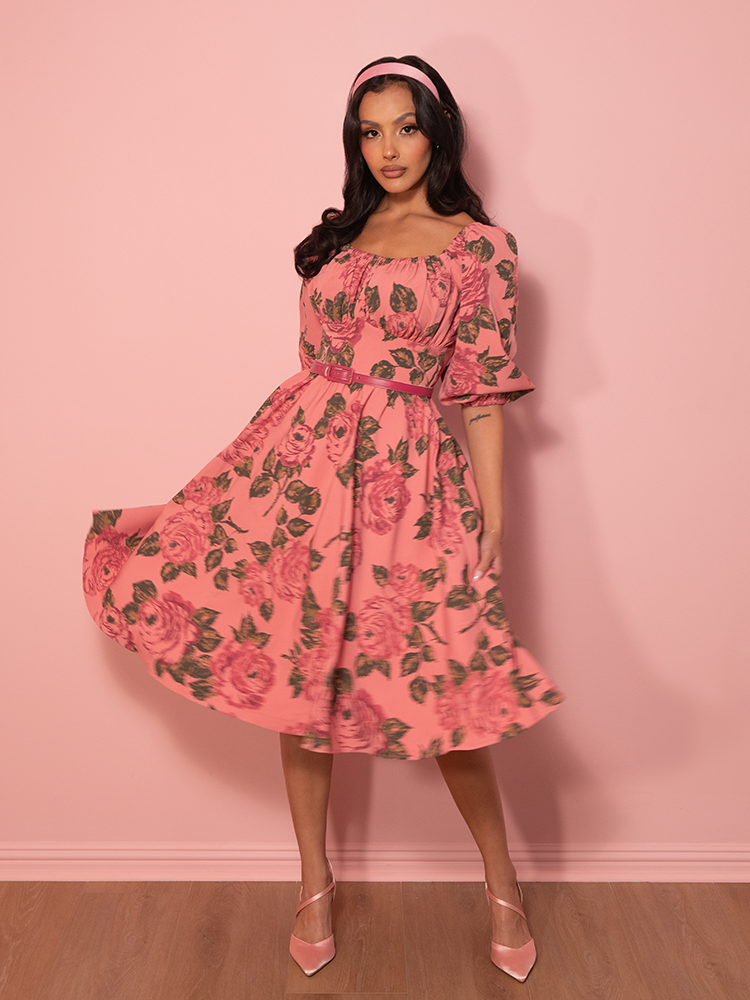 Channel effortless 1950s glamour, with this blush pink rose-print dress, designed for romantic strolls and timeless elegance.
