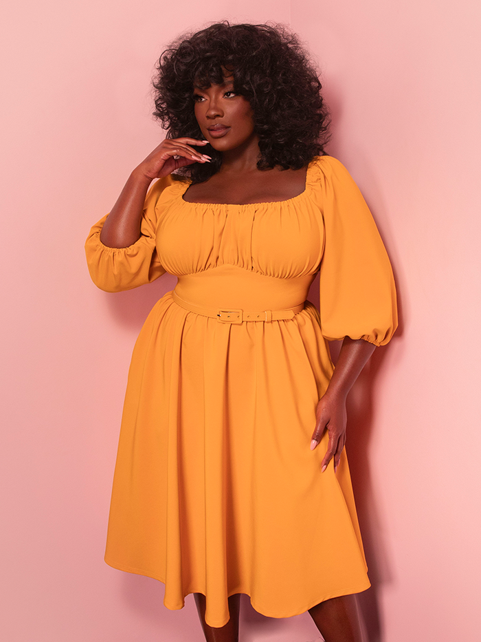 Bask in the charm of vintage-inspired fashion with the Vacation Dress in Mustard Gold. Its breezy silhouette and radiant hue evoke the elegance of classic Hollywood summer getaways.