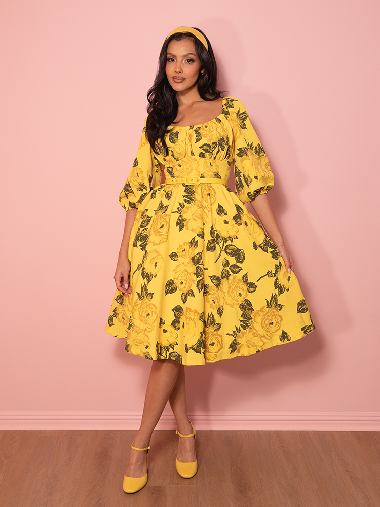 A floral fantasy in golden hues, this vintage-style vacation dress features soft yellow roses on a flattering fit-and-flare silhouette.
