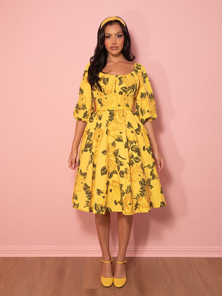 Fresh and flirty, this yellow rose-covered vacation dress captures the essence of vintage summer style with its graceful, romantic design.
