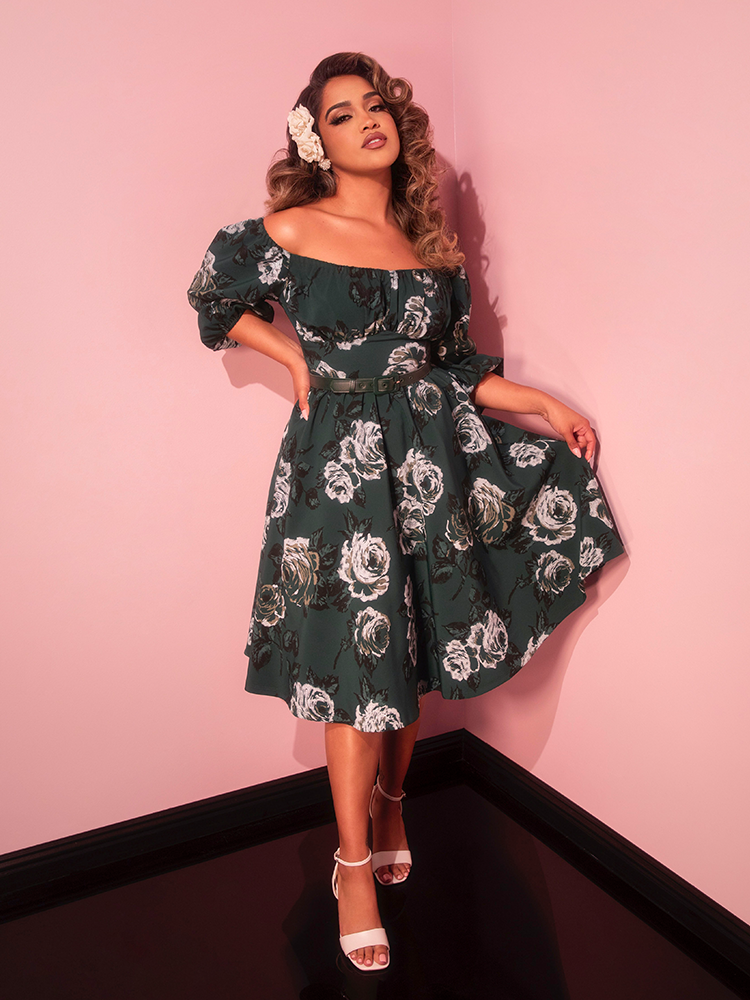 Make a statement on your getaway with this vintage-inspired dress featuring lush green roses and a flattering silhouette. Channel classic Hollywood allure while enjoying the breeze.