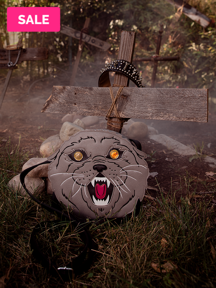 Pet Sematary Church the Cat Body Bag from Vixen Clothing pictured against a makeshift cross.