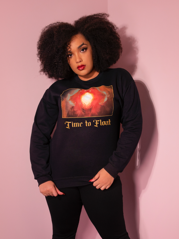 Looking at the camera, Ashleeta models the Time to Float Sweatshirt by Vixen Clothing.