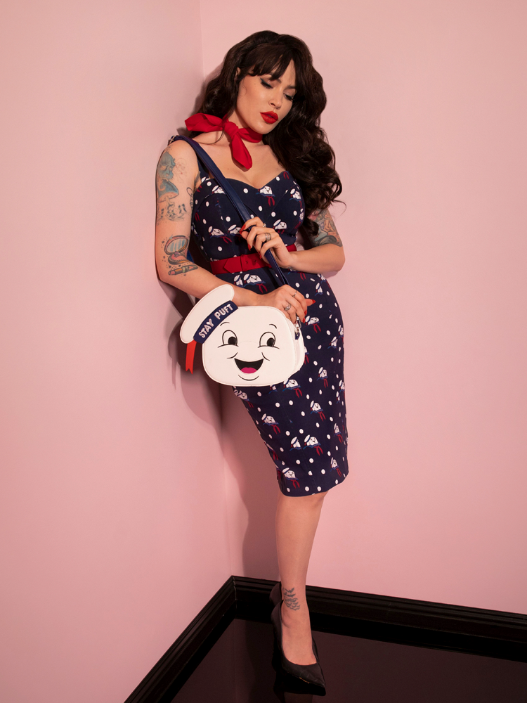 Micheline Pitt pairing the all new GHOSTBUSTERS™ Maneater Wiggle Dress in Stay Puft Novelty Print with the matching Stay Puft bag - all items from Vixen Clothing.